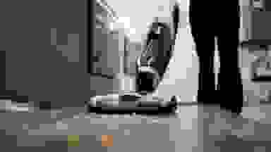 Person in black pants vacuums raw pasta off a bare floor