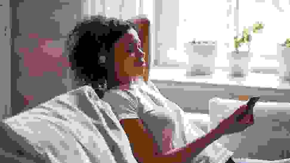 Woman sits on her couch meditating