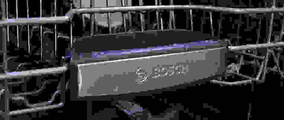 A close-up of the front of a Bosch dishwasher's top rack, which has the Bosch logo on it.
