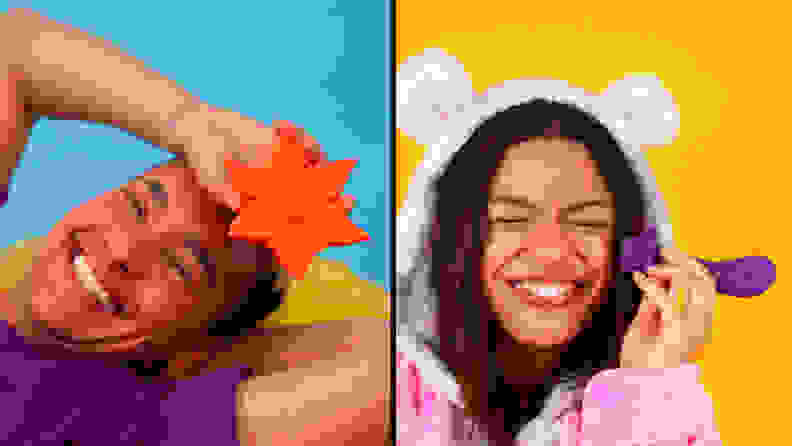 Two people holding bright colored objects next to their faces and smiling