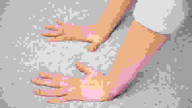 a woman's hands press into the surface of the Casper mattress