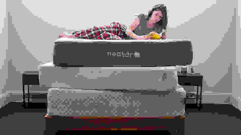 a woman lies down on a stack of mattresses reading