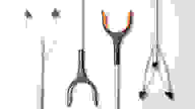 Four different reacher grabber tools on a white background