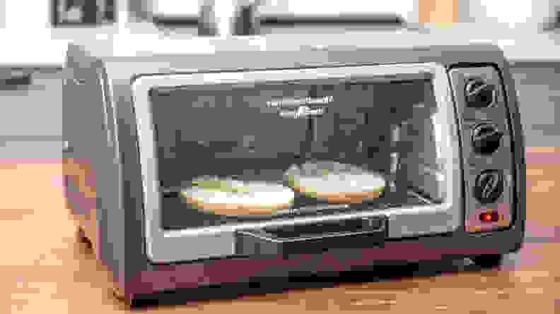 Bagel toasting in a Hamilton Beach toaster oven.