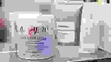 A jar and tube of moisturizer next to each other on a shelf.