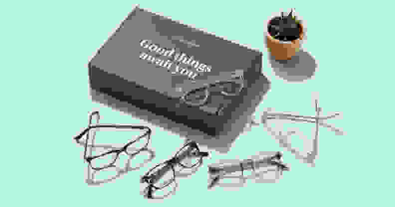 Warby Parker glasses on blue table next to box.