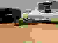 The iRobot Roomba j7+ and Samsung JetBot A.I.+ sit on a table with fake pet poop in front of them