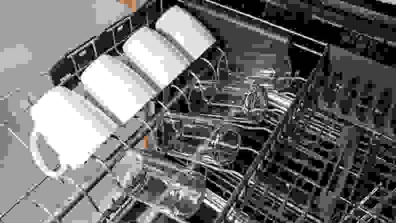 The third rack of the KitchenAid KDTM404KPS dishwasher with mugs and glasses on one side of it.