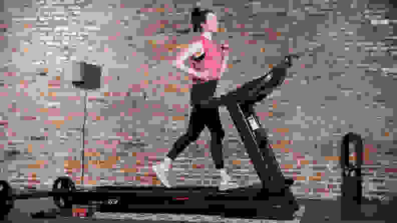 A woman uses the Sole F63 treadmill.