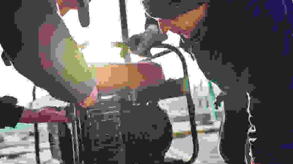 Two workers repair a portable generator.