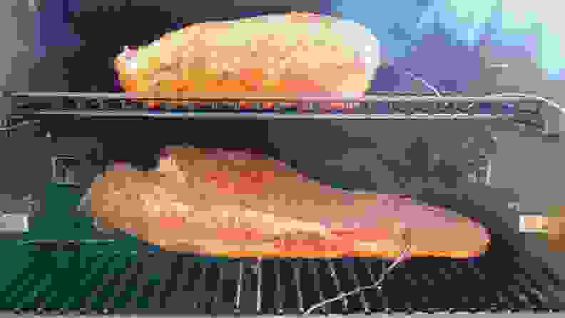Two briskets being cooked in the Traeger grill with inserted probe thermometers