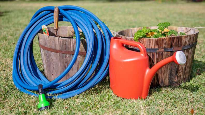A garden hose draped over a wooden barrel