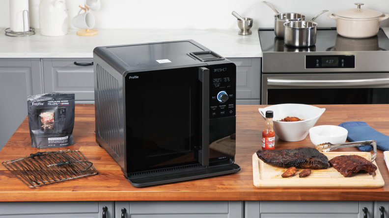 GE indoor smoker on a countertop surrounded by smoked meats