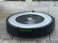 A iRobot vacuum on a stone patio
