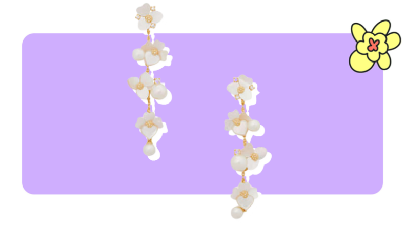 A pair of Precious Pansy Statement Linear floral drop earrings from Kate Spade in front of purple background with a yellow cartoon flower in the corner.