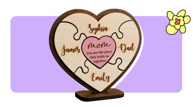 A carved wood plaque into the shape of a heart with puzzle pieces inside in front of purple background with a yellow cartoon flower in the corner.