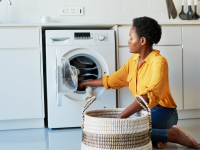 Woman doing laundry in her kitchen at home