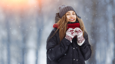 Girl bundled up in the snow wearing a winter coat.